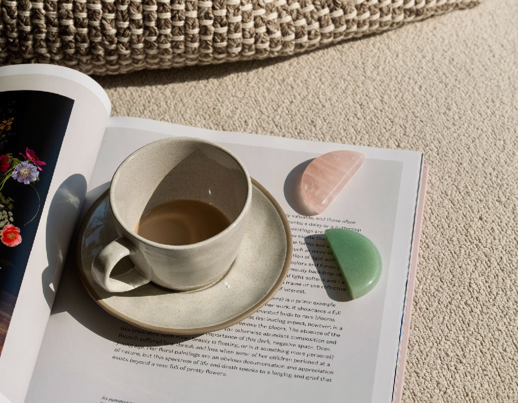 Rose Quartz and Green Aventurine stones on an open book for heart chakra healing ritual