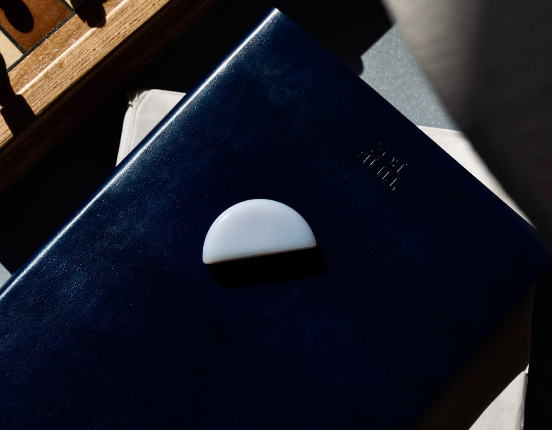 Blue Chalcedony tumbled stone on journal for throat chakra and honest communication