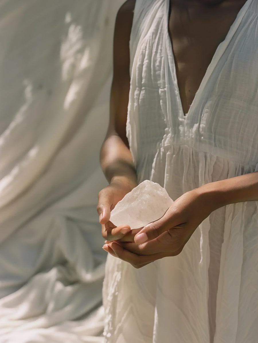 Hands holding a clear quartz crystal for calm and balance