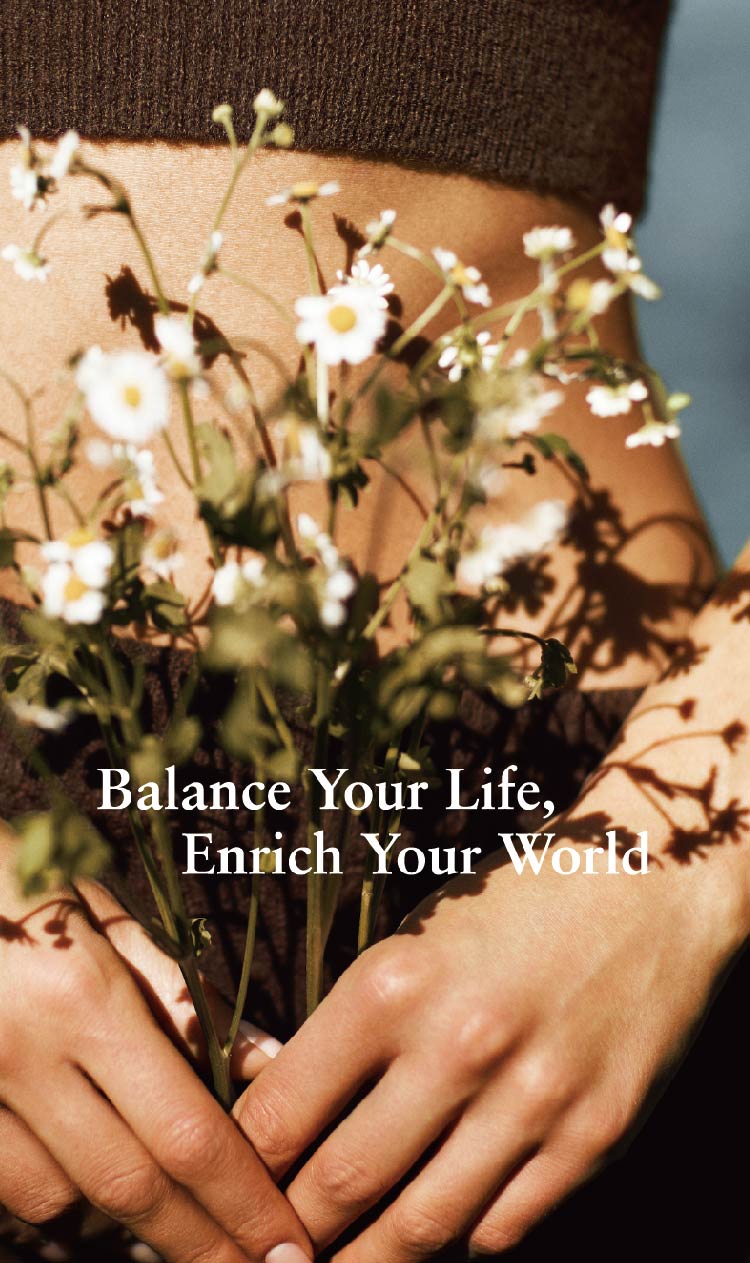 Person holding a bouquet of flowers with text 'Balance Your Life, Enrich Your World' on a blurred background
