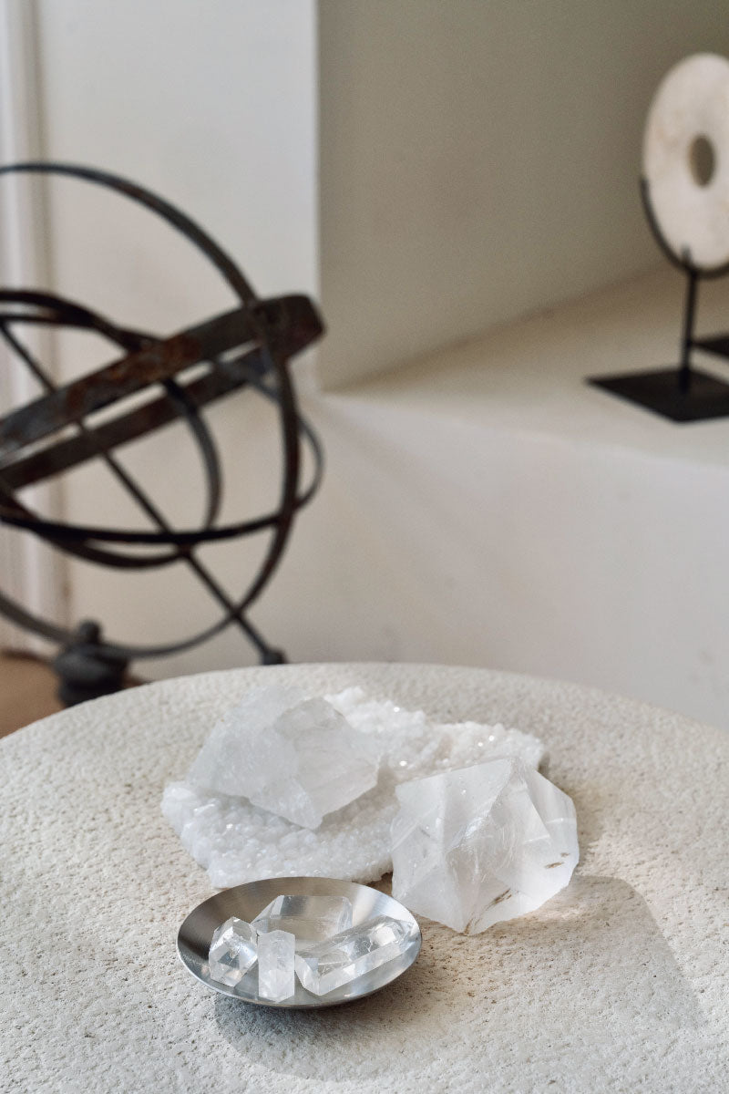 Sunlit setting featuring massive Quartz Clusters amplifying solar energy to recharge smaller healing stones placed nearby