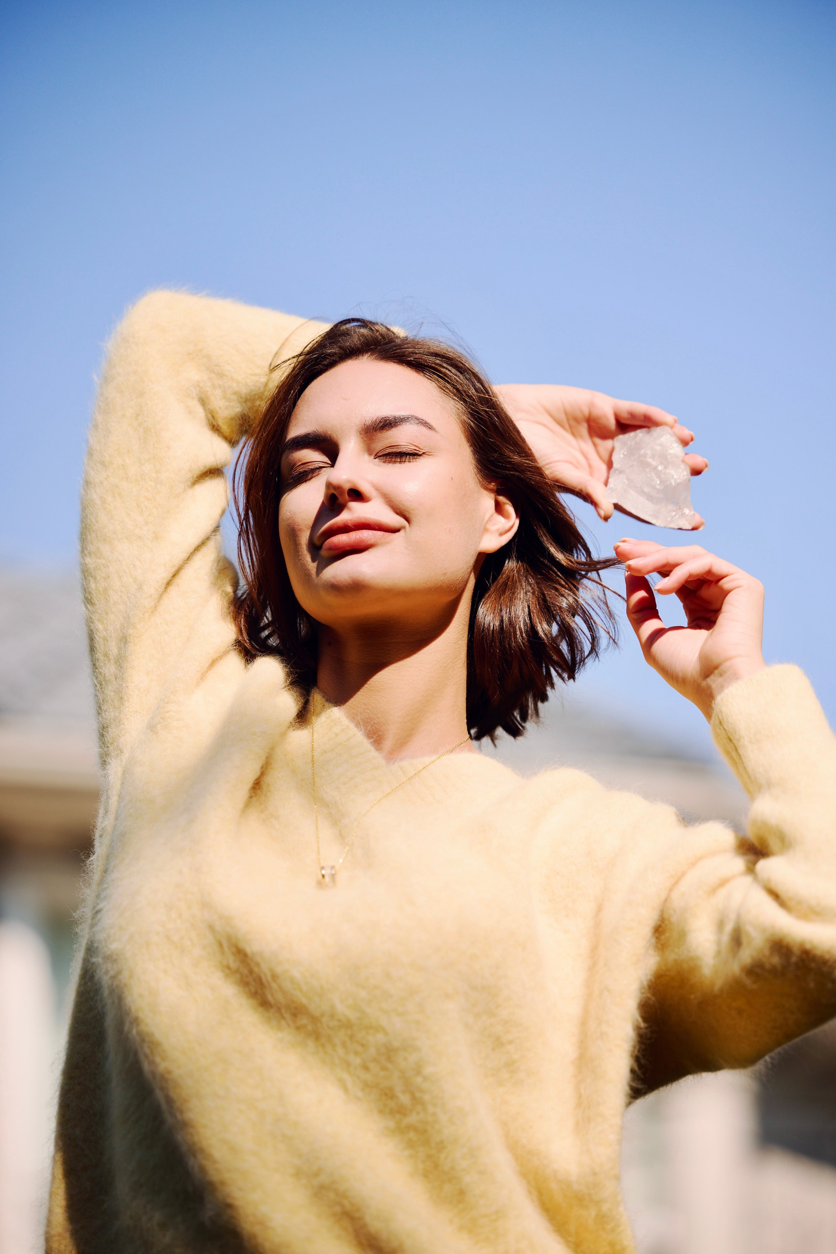 Orblink Clear Quartz Lifestyle - Woman Holding Raw Crystal in Sunlight for Energy Cleansing & Purification