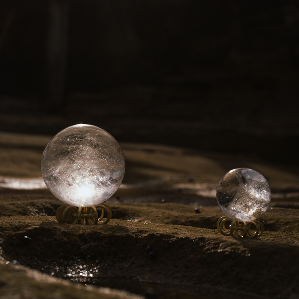 Small and large Orblink Himalayan Quartz Crystal Balls displayed on stones