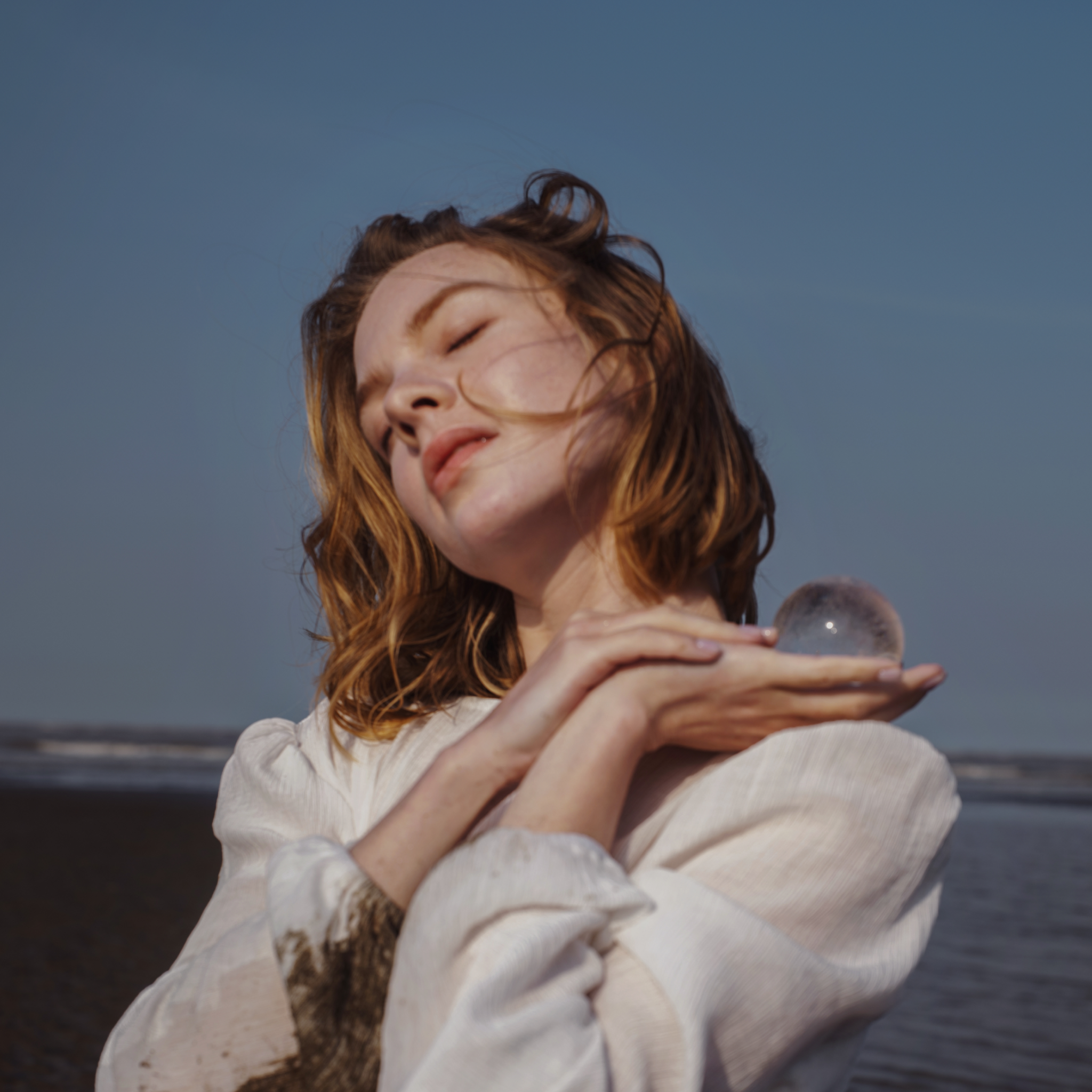 Woman Cradling a Himalayan Crystal Sphere, Showcasing Natural Energy and Healing Properties